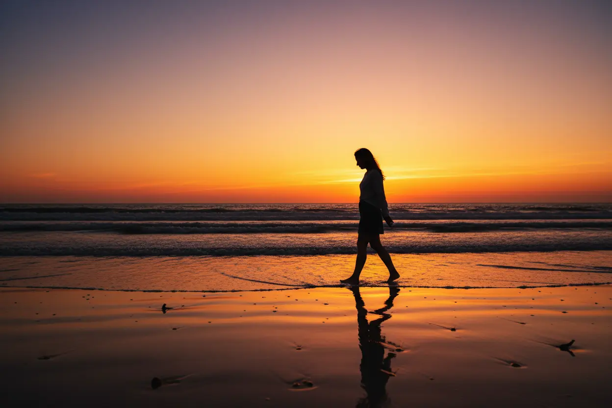 Mulher em caminhada solitária na praia.