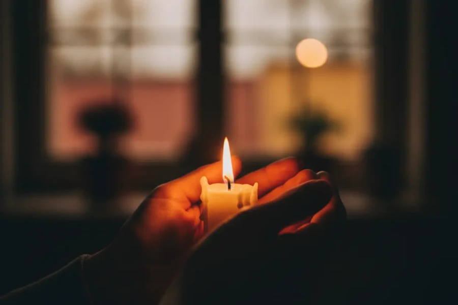 Lighted candle in hand, symbol of hope
