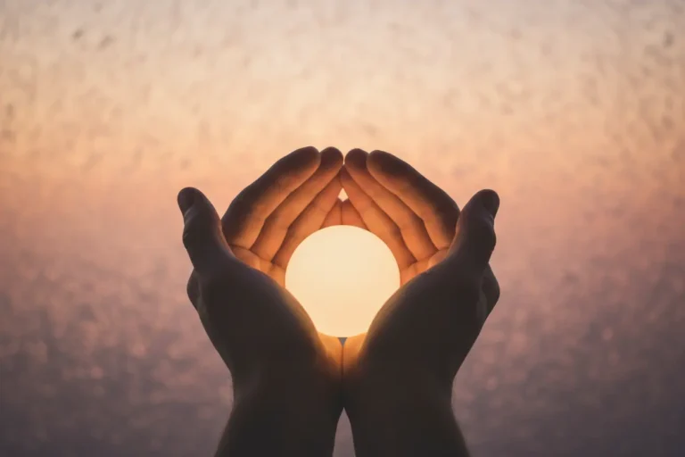 Mãos segurando uma luz, simbolizando uma mensagem de superação.