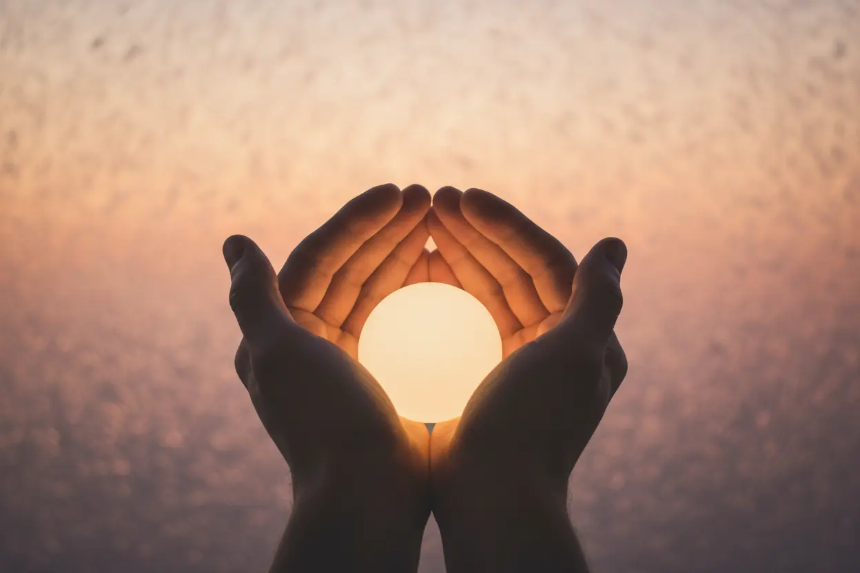 Mãos segurando uma luz, simbolizando uma mensagem de superação.